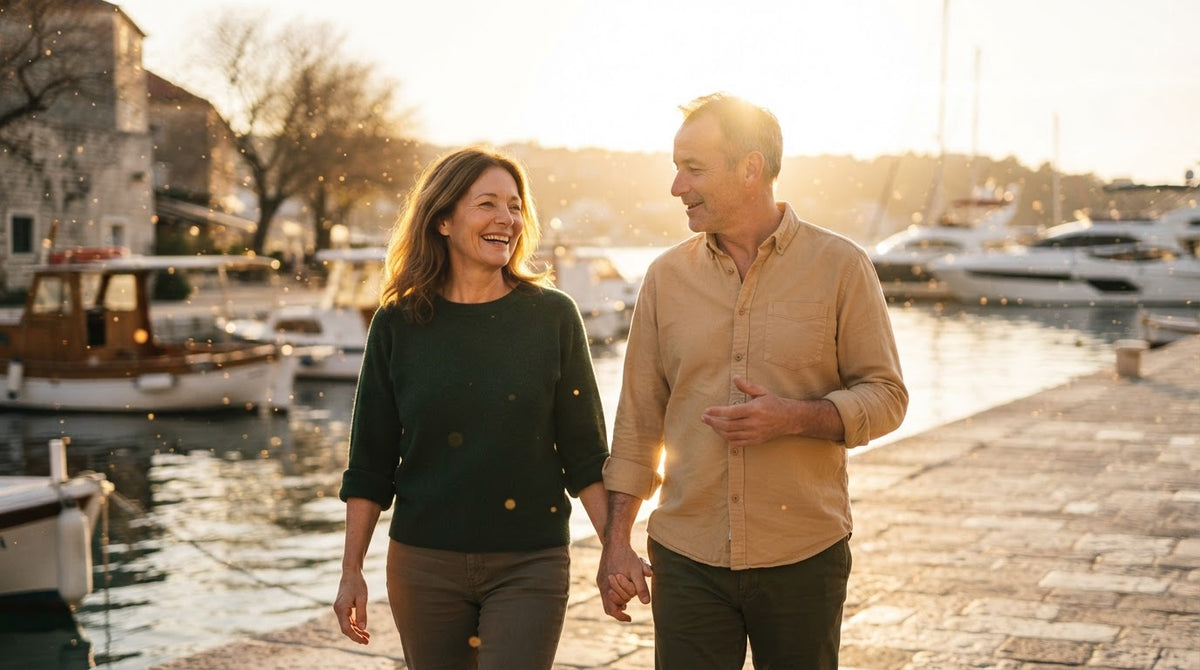Frau und Mann um die 50 spazieren an einem sonnigen Frühlingstag an der Hafenpromenade
